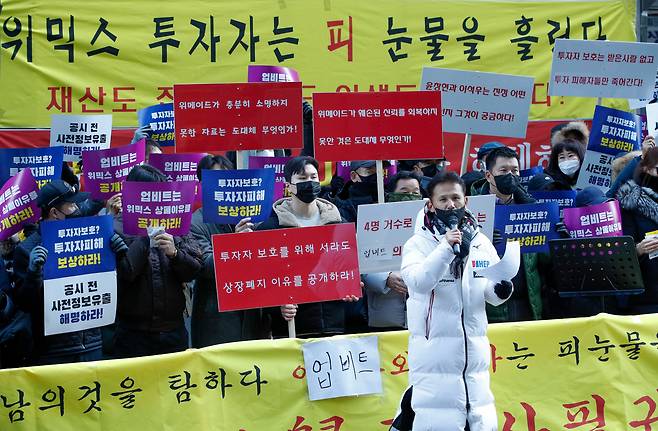 지난해 12월 2일 오후 서울 강남구 가상자산 거래소 업비트 건물 앞에서 위믹스 투자자들이 위믹스 상장 폐지 이유 공개와 투자자 피해보상 촉구 집회를 하고 있다. /뉴스1