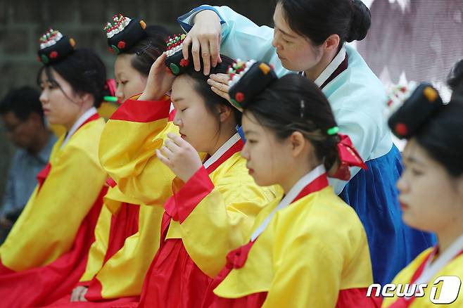 성년의날을 하루 앞둔 14일 오후 서울 중구 덕수궁 돌담길에서 열린 '전통 성년례'에서 올해 성년을 맞은 대학생들이 의복과 족두리를 착용하는 가례(加禮)를 치르고 있다. 2023.5.14/뉴스1 ⓒ News1 민경석 기자