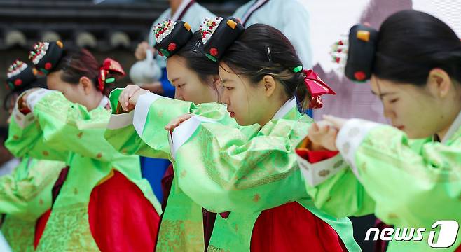 성년의날을 하루 앞둔 14일 오후 서울 중구 덕수궁 돌담길에서 열린 '전통 성년례'에서 올해 성년을 맞은 대학생들이 의복과 족두리를 착용하는 가례(加禮)를 치른 뒤 절을 하고 있다. 2023.5.14/뉴스1 ⓒ News1 민경석 기자