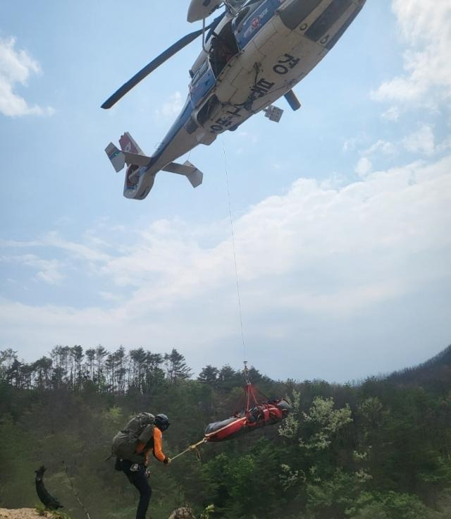 경북소방헬기가 지난 13일 경북 울진군 북면 덕구리 야산에서 산불에 탄 나무를 제거하다 다친 중국 국적의 70대 근로자를 이송하고 있다. 경북소방본부 제공