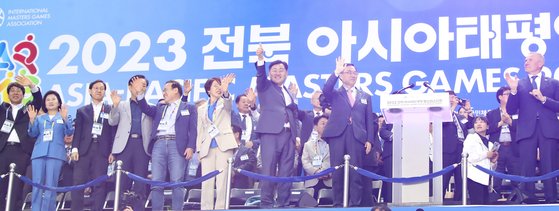 13일 전주월드컵경기장에서 열린 '2023 전북 아시아·태평양(아태) 마스터스대회' 개회식에서 대회 조직위원장인 김관영 전북지사와 세르게이 부브카 국제마스터스대회협회(IMGA) 회장, 조용만 문화체육관광부 제2차관을 비롯한 서거석 전북교육감, 국주영은 전북도의회 의장, 김윤덕·김성주·강성희 국회의원 등이 입장하는 선수단을 향해 손을 흔들고 있다. [사진 전북도]