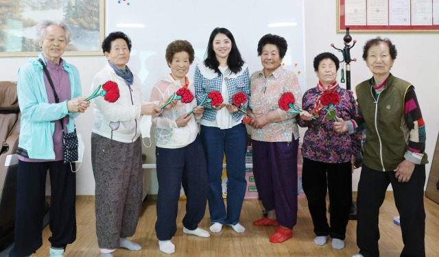 경북 칠곡군 가산면 학산1리에서 성인문해 교육을 담당하고 있는 김도현 씨가 스승의 날을 맞아 할머니들이 직접 만든 카네이션을 전달 받고 있다.  칠곡군 제공