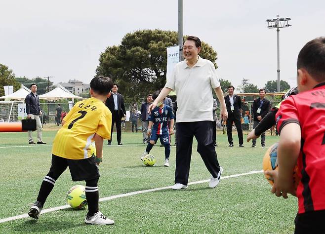 [서울=뉴시스] 전신 기자 = 윤석열 대통령이 14일 서울 용산어린이정원 내 축구장에서 열린 축구 클리닉에서 전국 유소년 축구대회에 참가한 어린이 선수들과 즐거운 시간을 보내고 있다. (대통령실통신사진기자단) 2023.05.14.