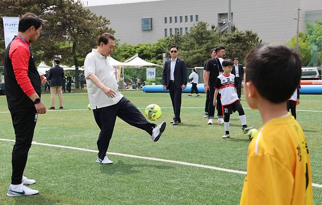 윤석열 대통령이 휴일인 14일 서울 용산 어린이정원 내 축구장에서 김태영 대한축구협회 사회공헌위원장 주관으로 진행된 축구 클리닉에서 전국 유소년 축구대회에 참가한 어린이 선수들과 공다루기 시합을 하고 있다. [연합]