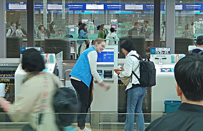 [인천공항=뉴시스] 홍찬선 기자 = 지난 12일 인천국제공항 제2여객터미널에서 벨라루스 출신 김리자베타씨가 승객들에게 셀프백드롭 서비스를 안내하고 있다. 2023.05.14. mania@newsis.com *재판매 및 DB 금지