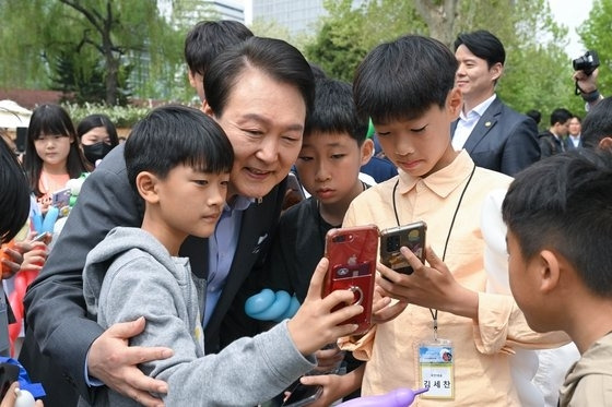 윤석열 대통령이 지난 4일 서울 용산 어린이정원 개방행사에서 어린이들과 기념촬영을 하고 있다. 대령실 제공