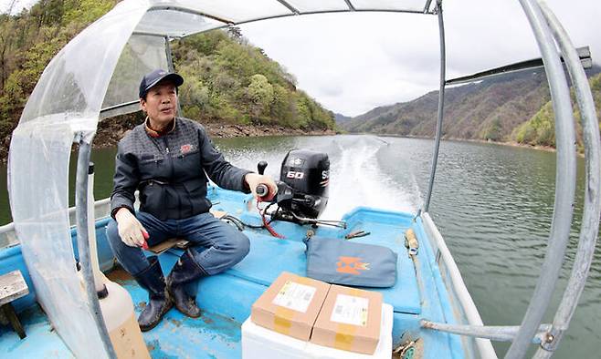 강원도 화천 평화의 댐 선착장에서 보트에 우편물을 싣고 김상준 집배원이 바람 거센 파로호를 힘차게 달리고 있다.