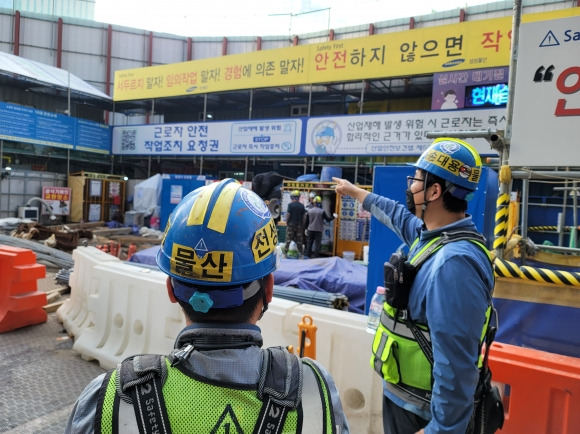 10일 서울의 한 오피스 건설 현장에서 한 근로자가 현수막을 보며 동료에게 작업중지권에 대해 설명하고 있다. 삼성물산 제공