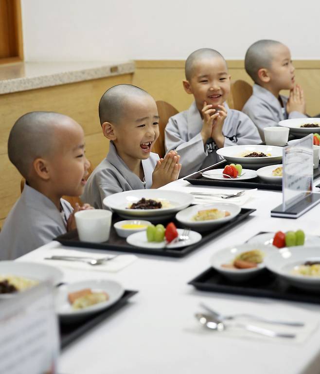 15일 서울 종로구 조계사에서 단기출가 과정 ‘보리수 새싹학교’에 참가한 동자승들이 신세계푸드가 박성희 사찰음식전문가와 함께 개발한 식물성 어린이 영양식단을 즐기고 있다./신세계푸드