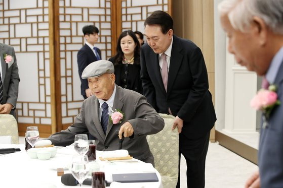 윤석열 대통령이 15일 대통령실 청사에서 스승의 날 기념 현장교원 초청 오찬 간담회에서 충암고 시절 은사인 최윤복 선생님의 착석을 돕고 있다. 대통령실통신사진기자단