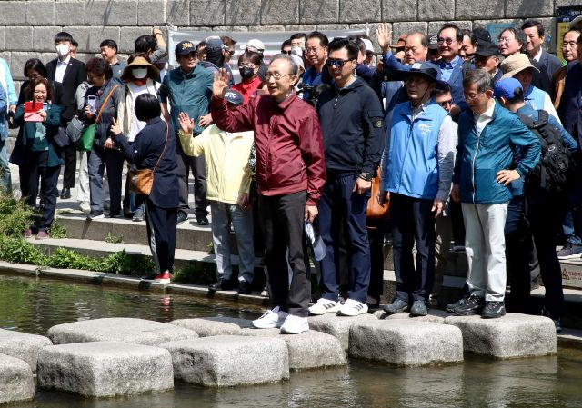 이명박 전 대통령이 15일 서울 청계천에서 '청계천을 사랑하는 모임'(청사모) 구성원들, 옛 참모들과 함께 산책하고 있다. 공동취재