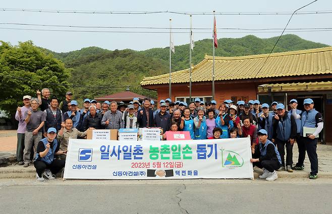 신동아건설 임직원들이 강원도 영월군 덕전마을에서 농촌봉사활동을 실시한 뒤 주민들과 기념사진을 촬영하고 있다. [사진 제공 = 신동아건설]