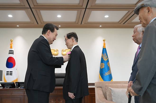 [서울=뉴시스] 윤석열 대통령이 15일 서울 용산 대통령실 청사에서 열린 제42회 스승의 날 기념 현장교원 초청 오찬 간담회에 앞서 윤 대통령의 대광초 시절 은사인 이승우 선생님 등에게 카네이션을 달아주고 있다. (사진=대통령실 제공) 2023.05.15. photo@newsis.com *재판매 및 DB 금지