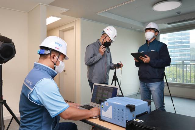 삼성물산 포스코이앤씨 롯데건설 관계자가 함께 층간소음 관련 실험을 하는 모습. 포스코이앤씨 제공