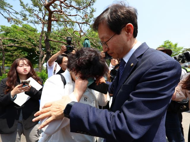 대한간호사협회 관계자가 16일 용산 대통령실 앞에서 열린 간호법 공포 촉구 기자회견이 끝난 뒤 눈물을 흘리고 있다. 김성주 더불어민주당 의원이 이 관계자를 위로하고 있다. 연합뉴스