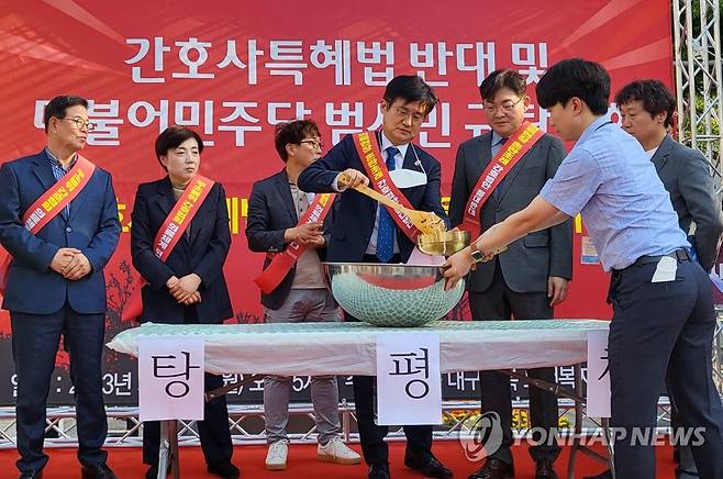 '간호사법 결사반대' (대구=연합뉴스) 박세진 기자 = 대구경북보건복지의료연대가 15일 대구 동성로에서 간호사특혜법 반대 및 더불어민주당 범시민 규탄대회를 열고 화합을 상징하는 탕평채를 만들어 먹는 퍼포먼스를 선보이고 있다. 의료연대는 더불어민주당을 향해 탕평정치를 촉구하는 등의 뜻을 전달하기 위해 퍼포먼스를 벌였다. 2023.5.15 psjpsj@yna.co.kr