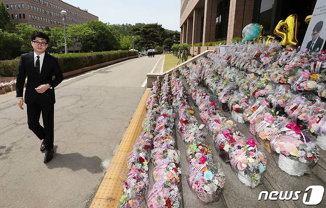 한동훈 법무부 장관이 17일 경기도 과천시 법무부 청사로 출근하며 지지자들이 보낸 꽃을 바라보고 있다.  2023.5.17/뉴스1 ⓒ News1 박세연 기자