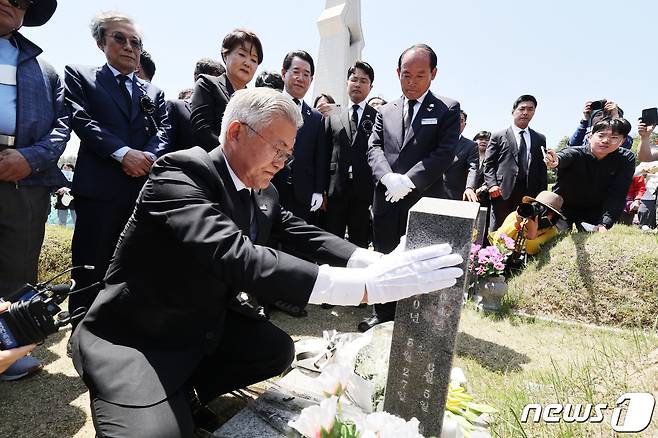 문재인 전 대통령이 17일 오전 광주 북구 운정동 국립5·18민주묘지를 찾아 고(故) 문재학 열사의 묘역을 참배한 후 명비를 어루만지고 있다. (공동취재) 2023.5.17/뉴스1 ⓒ News1 황기선 기자