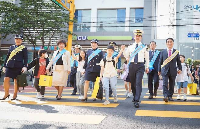 윤희근 경찰청장이 17일 오전 어린이 보호구역 안전시설 현장점검 차 서울 구로구 덕의초등학교를 방문해 어린이들과 함께 노란색 횡단보도를 건너고 있다. 사진=경찰청 제공