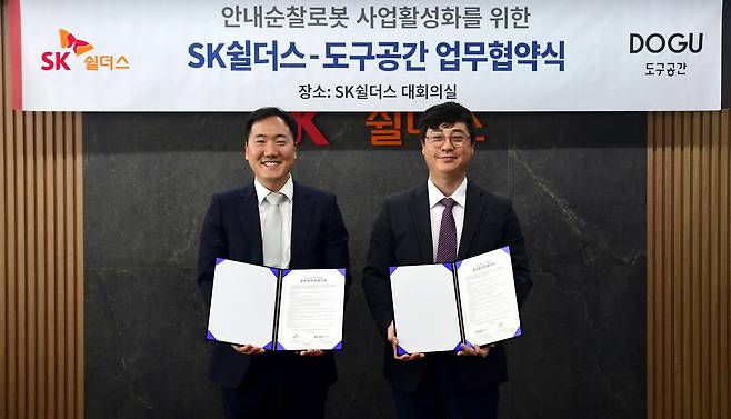 지난 16일 SK쉴더스와 도구공간이 안내순찰로봇 사업 협력을 위한 업무협약을 체결했다. 김윤호 SK쉴더스 성장추진실장(오른쪽)과 김진효 도구공간 대표가 사진 촬영을 하고 있다./SK쉴더스