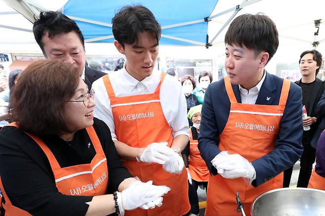 전두환 전 대통령의 손자인 전우원씨(맨 앞줄 가운데)와 이준석 국민의힘 전 대표(〃 〃 오른쪽)가 17일 오후 광주 동구 금남로에서 열린 ‘오월 주먹밥’ 나눔 행사에 나란히 참여하고 있다. 이들은 1980년 5월 광주 공동체를 재현한 ‘시민난장’에서 우연히 만났다. 광주=연합뉴스