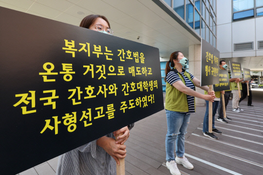 고려대 안암병원 간호사와 전국보건의료산업노동조합 조합원들이 16일 오후 조규홍 보건복지부 장관이 현장 방문한 서울 고려대학교 안암병원에서 윤석열 대통령의 간호법 제정안에 대한 법률안 거부권 행사를 규탄하며 손팻말을 들고 있다. [연합뉴스]