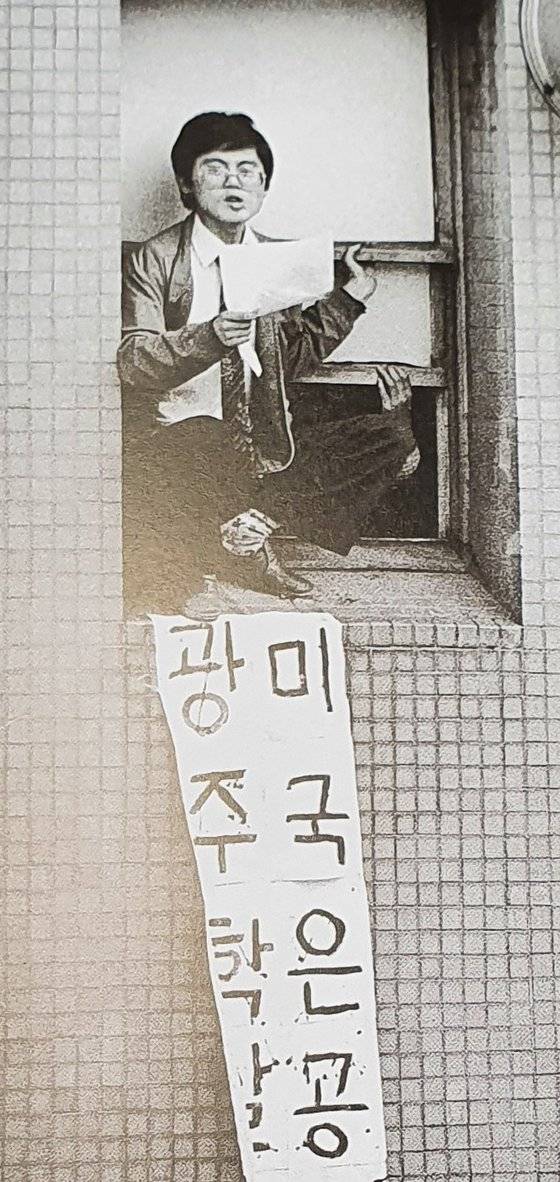 1985년 5월 23일 서울 미국문화원을 점거한 서울대 삼민투 위원장 함운경(당시 서울대 물리학과 재학)이 창밖으로 반미 구호를 외치고 있다. [전민조 사진 선집 '사진이 다 말해 주었다' 지면 촬영]