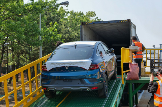 Renault Korea Motors' Arkana SUVs are being loaded into a shipping container at the French carmaker's plant in Busan on Wednesday. [RENAULT KOREA MOTORS]