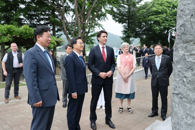 서태원 가평군수, 김동연 경기도지사, 트뤼도 캐나다 총리가 18일 캐나다 참전 가평전투지 숲길에 조성된 전투기념비를 바라보고 있다. 가평군 제공