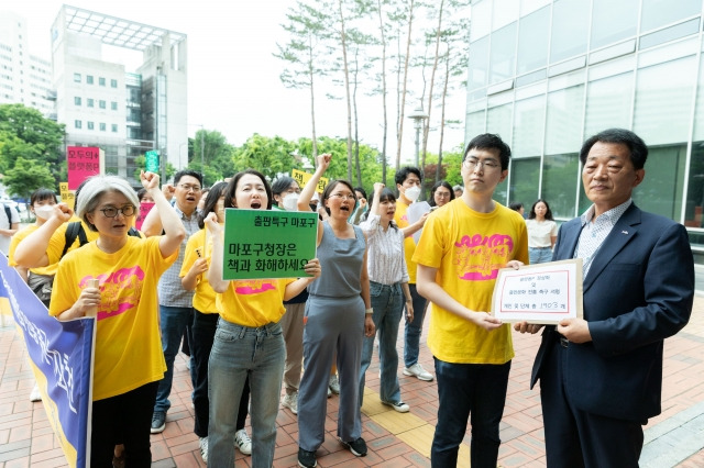 18일 오전 서울 마포구 마포구청 앞에서 '플랫폼P 정상화 및 출판문화 진흥 촉구 기자회견'을 마친 플랫폼피입주사협의회가 구청 공무원에서 서명을 전달하고 있다. 플랫폼피입주사협의회 제공