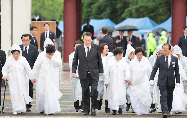 윤석열 대통령이 18일 광주 북구 국립5·18민주묘지에서 열린 제43주년 5·18민주화운동 기념식에 오월어머니회 회원들과 함께 입장하고 있다. [연합]