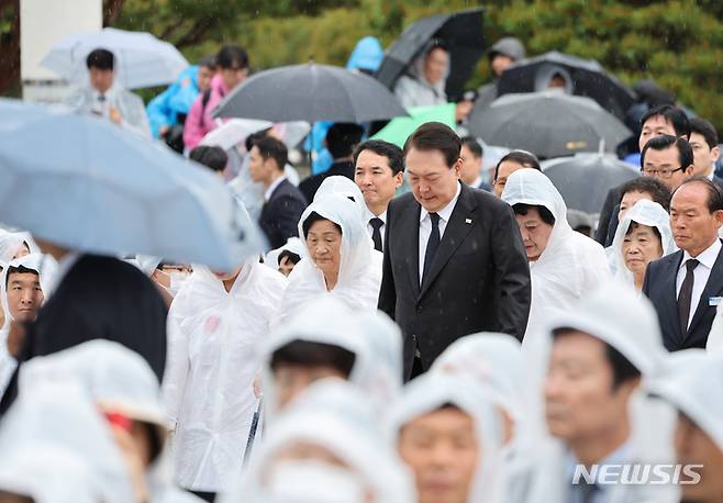 [광주=뉴시스] 홍효식 기자 = 윤석열 대통령이 18일 광주 북구 국립5·18민주묘지에서 열린 제43주년 5·18민주화운동 기념식에 오월어머니회 회원들과 함께 입장하고 있다. (대통령실통신사진기자단) 2023.05.18. yesphoto@newsis.com