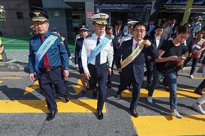 윤희근 경찰청장(앞줄 왼쪽에서 두 번째)이 지난 17일 오전 어린이보호구역 안전시설 현장점검을 위해 서울 구로구 덕의초등학교를 방문해 노란색 횡단보도를 건너보고 있다. 연합뉴스