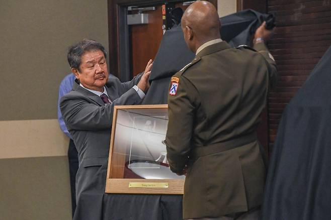 미 육군 지휘참모학교 명예의전당에 헌액된 '전쟁영웅' 김영옥 대령 (캔자스=연합뉴스) 미국의 전쟁 영웅 고(故) 김영옥 대령이 16일(현지시간) 미 캔자스주 포트 레번워스에 있는 미 육군 지휘참모학교 명예의 전당에 헌액됐다. 사진은 김영옥 재미동포연구소장인 장태한 교수(왼쪽)와 미 육군 관계자가 헌액 기념식을 진행하는 모습. [U.S. Army Combined Arms Center 페이스북 제공. 재판매 및 DB 금지]