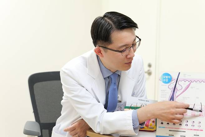 모발은 성장기와 휴지기를 반복한다. 머리카락의 뿌리를 감싸고 있는 모낭을 자극하면 탈모를 막고 발모를 유도할 수 있다. 권오상 교수가 모낭의 구조를 설명하고 있다. 서울대병원 제공