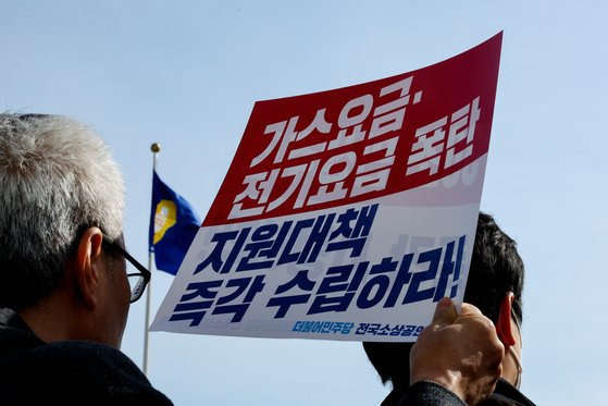 지난 2월 15일 더불어민주당 전국소상공인위원회 관계자가 국회 본청 앞에서 열린 가스요금·전기요금 폭탄 지원 대책 수립 촉구 기자회견에서 관련 손팻말을 들고 있다. 연합뉴스