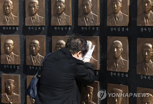 보고 싶다  2023년 3월 26일 오전 경기도 평택시 해군 제2함대 사령부에서 열린 '제13주기 천안함 46용사 추모식'에서 유가족이 추모비에 새겨진 얼굴을 어루만지고 있다.
 [연합뉴스 자료사진]