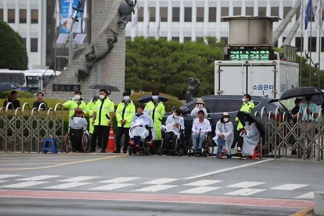 경남장애인차별철폐연대가 봉쇄된 도청 정문 앞에서 농성을 벌이고 있다. [사진=이세령 기자]