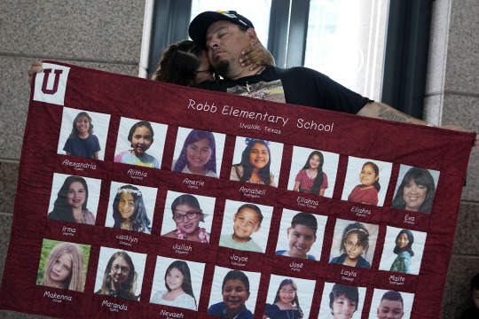 유밸디 초등학교 총기 난사 사건 유족이 희생자들을 기리는 보드판을 들고 있습니다. AP연합뉴스