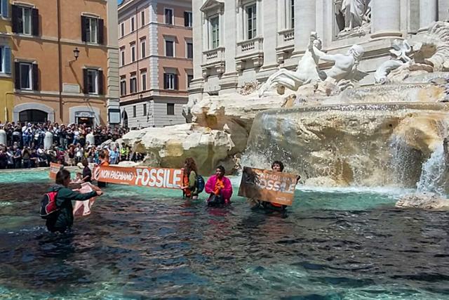 이탈리아 환경단체 울티마 제네라치오네의 활동가들이 21일 식물성 먹물을 로마 트레비 분수에 부은 뒤 물속으로 들어가 기후변화의 심각성을 알리는 시위를 하고 있다. 로마=AFP 연합뉴스