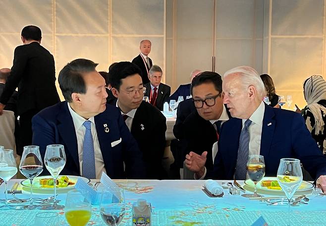 윤석열 대통령이 20일 오후 일본 히로시마 그랜드 프린스 호텔에서 열린 G7 정상회의 친교 만찬에서 조 바이든 미국 대통령과 대화하고 있다. [연합]