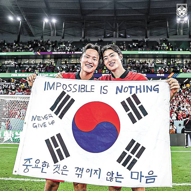 축구대표팀 조규성(오른쪽)과 권경원이 카타르월드컵 16강행 확정 후 팬이 건네준 중꺾마가 적힌 태극기를 펼쳐 보이고 있다. 사진 대한 축구협회