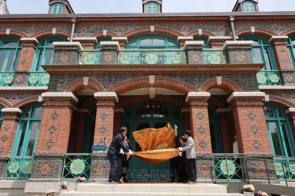 22일 서울 중구 덕수궁 돈덕전에서 열린 현판 제막식에서 관계자들이 현판을 가리고 있던 천을 걷어 내고 있다. 홍윤기 기자