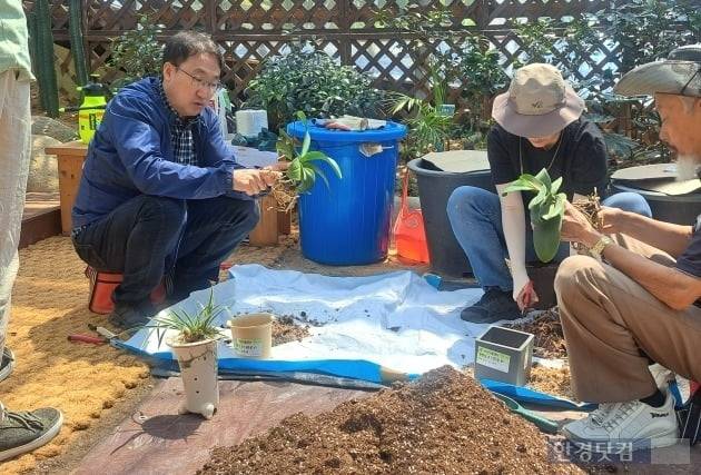식물의 분갈이 법을 가르쳐주고 있는 주 원장과 병원 관계자들. /사진=김세린 기자