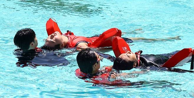 수상안전요원들이 익수자를 구조하는 훈련을 하고 있다.