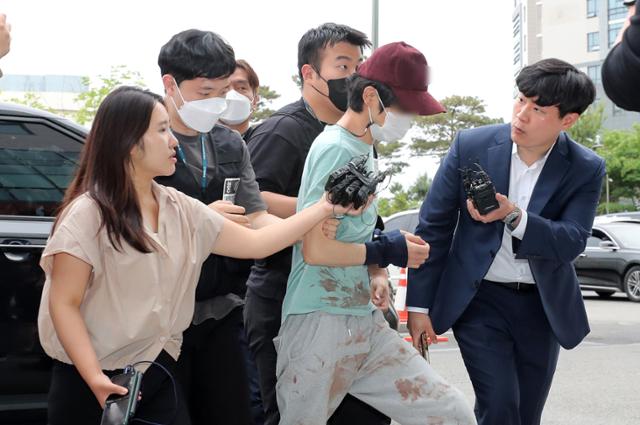 동거녀를 살해한 혐의를 받는 피의자 김모씨가 26일 서울 금천구 금천경찰서로 압송되고 있다. 뉴스1