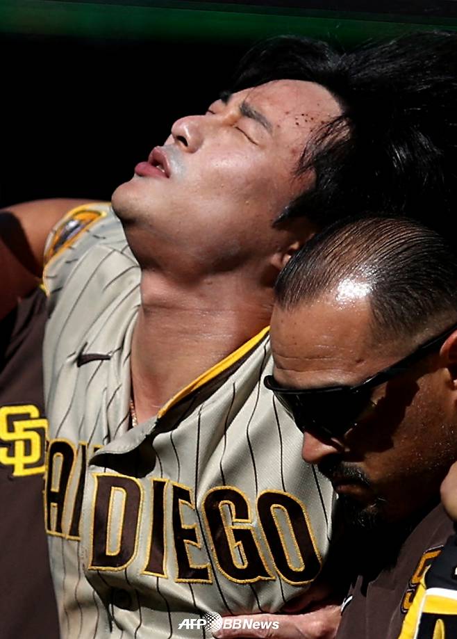 김하성(왼쪽)이 26일(한국시간) 워싱턴 내셔널스와 원정 경기에서 2회 자신의 파울 타구에 무릎을 강타당한 뒤 트레이너들의 부축을 받으며 그라운드를 빠져나가고 있다. /AFPBBNews=뉴스1