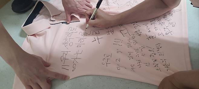 작년 6월 21일 누리호 2차 발사 성공 직후 한국항공우주연구원 연구진이 단체 티셔츠에 성공을 자축하는 메시지를 적고 있는 모습. /오승협 한국항공우주연구원 책임연구원
