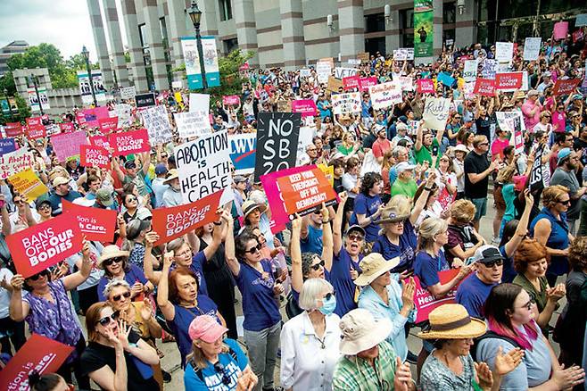 19일(현지 시간) 미국 노스캐롤라이나주 롤리 지역 바이센테니얼 몰 앞에서 낙태권을 지지하는 수백 명의 시위자들이 모여 ‘우리 몸을 금지하지 말아라(Bans off Our Bodies)’등의 문구가 담긴 팻말을 들고 시위하고 있다. 롤리=AP 뉴시스