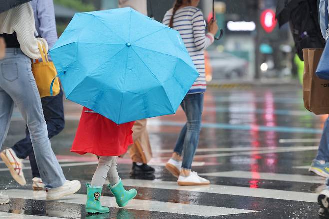 27일 오후 서울 광화문네거리에서 어린이가 우산을 쓰고 횡단보도를 건너고 있다. [연합]